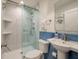 Modern bathroom with a glass-enclosed shower, pedestal sink with blue tiled trim and modern fixtures at 1365 Dunlin Court, Share C, Kiawah Island, SC 29455