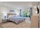 A bright bedroom with a view of greenery outside the window, a bed with blue comforter, and a wooden dresser at 1365 Dunlin Court, Share C, Kiawah Island, SC 29455