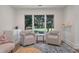 A bright living room featuring neutral decor and large windows with views of outdoor greenery at 1365 Dunlin Court, Share C, Kiawah Island, SC 29455