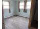 The bedroom has gray floors, light blue walls, and several windows covered by curtains at 1382 Doctor Evans Rd, Moncks Corner, SC 29461