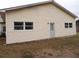 Exterior view of a single-story home with light siding, white windows, and a gray door at 1382 Doctor Evans Rd, Moncks Corner, SC 29461