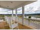 Inviting porch with white rocking chairs and lake view at 144 Maritime Way, Summerville, SC 29485