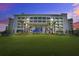 Beautiful three-story condominium complex with manicured lawn and blue skies at 16 Twin Oaks Lane Ln, Isle of Palms, SC 29451