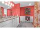 Stylish bathroom featuring double sinks, marble countertops, and decorative coral-colored walls and art at 1608 Marsh Harbor Ln # C, Mount Pleasant, SC 29464