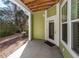 View of a covered patio with green siding, a white door, concrete flooring, and an exposed beam ceiling at 1712 Chatelain Way, Mount Pleasant, SC 29464