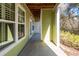 Covered patio space featuring green siding, white trim, and a concrete floor, perfect for outdoor relaxation at 1712 Chatelain Way, Mount Pleasant, SC 29464