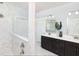 Modern bathroom featuring double sinks, dark cabinetry, and a glass-enclosed shower with marble tiling at 2094 Cousteau Ct, Johns Island, SC 29455