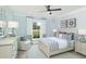 Cozy bedroom with light blue walls, a ceiling fan, and a large window offering natural light at 2094 Cousteau Ct, Johns Island, SC 29455