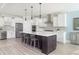 Bright, modern kitchen features stainless steel appliances, a wine fridge, and a large kitchen island with barstool seating at 2094 Cousteau Ct, Johns Island, SC 29455