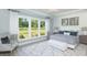 Serene main bedroom features lots of natural light from large windows, a queen-sized bed, and a sitting area at 2094 Cousteau Ct, Johns Island, SC 29455