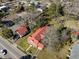 An aerial view of a charming home with a red roof nestled among mature trees and landscaped grounds at 222 E Main St, Moncks Corner, SC 29461