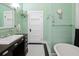 Bathroom featuring a dark wood vanity, mint green bead-board walls, and black and white tile floors at 222 E Main St, Moncks Corner, SC 29461