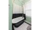 Bathroom featuring a black and white clawfoot tub with a black shower curtain and geometric tiled flooring at 222 E Main St, Moncks Corner, SC 29461