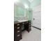 Bathroom featuring a dark wood vanity, large mirror, mint green bead-board walls, and black and white tile floors at 222 E Main St, Moncks Corner, SC 29461