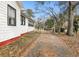 View of home's side and gated driveway with mature trees and landscaping at 222 E Main St, Moncks Corner, SC 29461