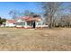 Charming white cottage-style home with red roof, surrounded by a lush green yard at 222 E Main St, Moncks Corner, SC 29461