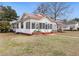 Charming home featuring a metal roof, covered porch, and well-maintained lawn at 222 E Main St, Moncks Corner, SC 29461
