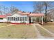 Charming cottage-style home with red metal roof, carport, and quaint curb appeal at 222 E Main St, Moncks Corner, SC 29461
