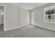 Bedroom features plush carpet, a large window, a white door with a glass panel, and neutral walls at 232 O'Malley Dr, Summerville, SC 29483