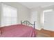 Bright bedroom featuring a dark metal bed frame, sheer curtains, and hardwood floors at 234 Rutledge Ave # D, Charleston, SC 29403