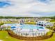 Aerial shot of a modern community pool with lounge chairs, cabanas and a slide, surrounded by green spaces and homes at 276 Watersglen Dr, Summerville, SC 29486