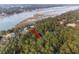 Aerial view of a house in a wooded area near a river with an arrow pointing to the property at 3348 River Landing Rd, Johns Island, SC 29455