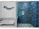 Modern bathroom with blue tiled shower, soaking tub, and glass partition at 3348 River Landing Rd, Johns Island, SC 29455