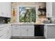 Bright kitchen featuring white cabinets, stone backsplash and a window view to the backyard at 3348 River Landing Rd, Johns Island, SC 29455