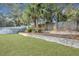 Well-maintained backyard featuring a lush lawn, palm trees, and a retaining wall for enhanced landscaping at 3632 Locklear Ln, Mount Pleasant, SC 29466