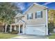Charming two-story home with tan siding, attached garage, and inviting front porch at 3632 Locklear Ln, Mount Pleasant, SC 29466