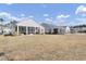 View of the backyard featuring a lawn and patio with neighboring homes in a well-maintained community at 376 Tupelo Lake Dr, Summerville, SC 29486