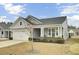 Inviting home featuring a covered porch, well-kept lawn, tidy shrubs and a 2-car attached garage at 376 Tupelo Lake Dr, Summerville, SC 29486
