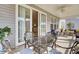 Covered patio area with outdoor seating at a round table and glimpses of the interior through sliding glass doors at 376 Tupelo Lake Dr, Summerville, SC 29486