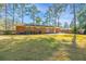 View of the brick home's backyard featuring a well-maintained lawn and a cozy patio for outdoor enjoyment at 715 Old Golf Rd, Summerville, SC 29483