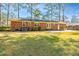 Spacious backyard featuring a brick house, concrete patio, green lawn, and tall trees at 715 Old Golf Rd, Summerville, SC 29483