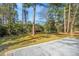 Extensive backyard with concrete patio, lush lawn, mature trees, and ample space at 715 Old Golf Rd, Summerville, SC 29483