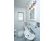 Bright bathroom featuring a toilet, sink, mirror, glass shelf, and a window with mini blinds at 715 Old Golf Rd, Summerville, SC 29483