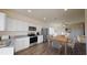 Open-concept kitchen features white cabinets, stainless appliances, and dining area with modern furnishings at 728 Pisces Ln, Summerville, SC 29486