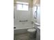 Bright bathroom featuring white tile, a bathtub with shower, and convenient grab bars at 7645 Knollwood Dr, North Charleston, SC 29418