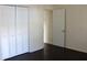 Bright bedroom featuring a closet with louvered doors and rich, dark flooring at 7645 Knollwood Dr, North Charleston, SC 29418