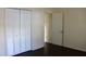 Bright bedroom featuring a closet with louvered doors and rich, dark flooring at 7645 Knollwood Dr, North Charleston, SC 29418