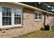 Brick home exterior featuring windows with clean trim and an air conditioner at 7645 Knollwood Dr, North Charleston, SC 29418