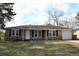 Ranch style home with a brick exterior, lush green lawn, and mature trees at 7645 Knollwood Dr, North Charleston, SC 29418