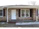 Cozy covered front porch with brick siding and dark shutters at 7645 Knollwood Dr, North Charleston, SC 29418
