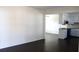 Living room area with dark hardwood floors, white walls, and views into the kitchen at 7645 Knollwood Dr, North Charleston, SC 29418