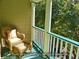 Inviting outdoor balcony with wicker furniture and views of surrounding greenery and bright sunlight at 8869 Marsh Aire Ln, Edisto Island, SC 29438