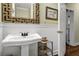 Bathroom with pedestal sink, decorative mirror and adjacent water closet at 8869 Marsh Aire Ln, Edisto Island, SC 29438