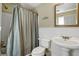 Cozy bathroom with beadboard paneling, pedestal sink, and shower featuring a striped curtain at 8869 Marsh Aire Ln, Edisto Island, SC 29438