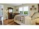 Serene bedroom with hardwood floors, large windows, and a vintage-style dresser and mirror at 8869 Marsh Aire Ln, Edisto Island, SC 29438