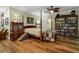 Bedroom featuring a 4-poster bed, hardwood floors and built-in shelving at 8869 Marsh Aire Ln, Edisto Island, SC 29438